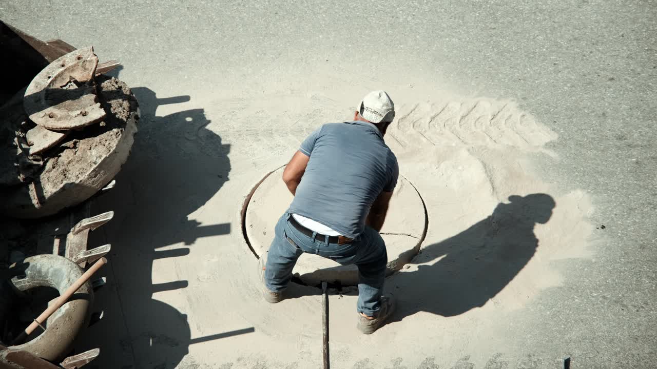 Worker removes the ring with a manhole cover.