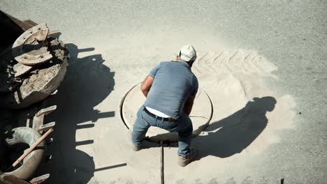 worker removes the ring with a manhole cover.