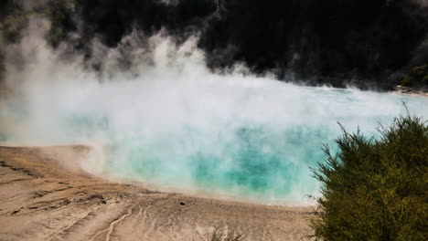 vapor que sube del lago del cráter inferno en waimangu durante el día soleado - toma panorámica