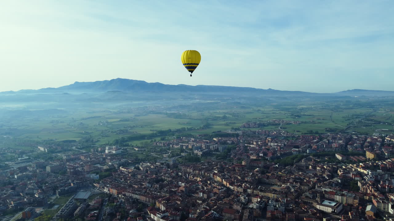 Hot Air Balloon over Cityscape and Valley