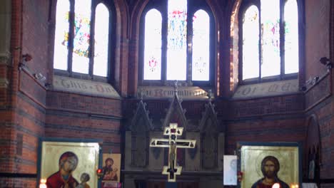 Toma-Inclinada-Hacia-Arriba-De-Un-Altar-En-Una-Antigua-Iglesia,-Mostrando-Vidrieras