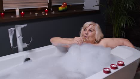 woman relaxing in a bubble bath with a glass of champagne