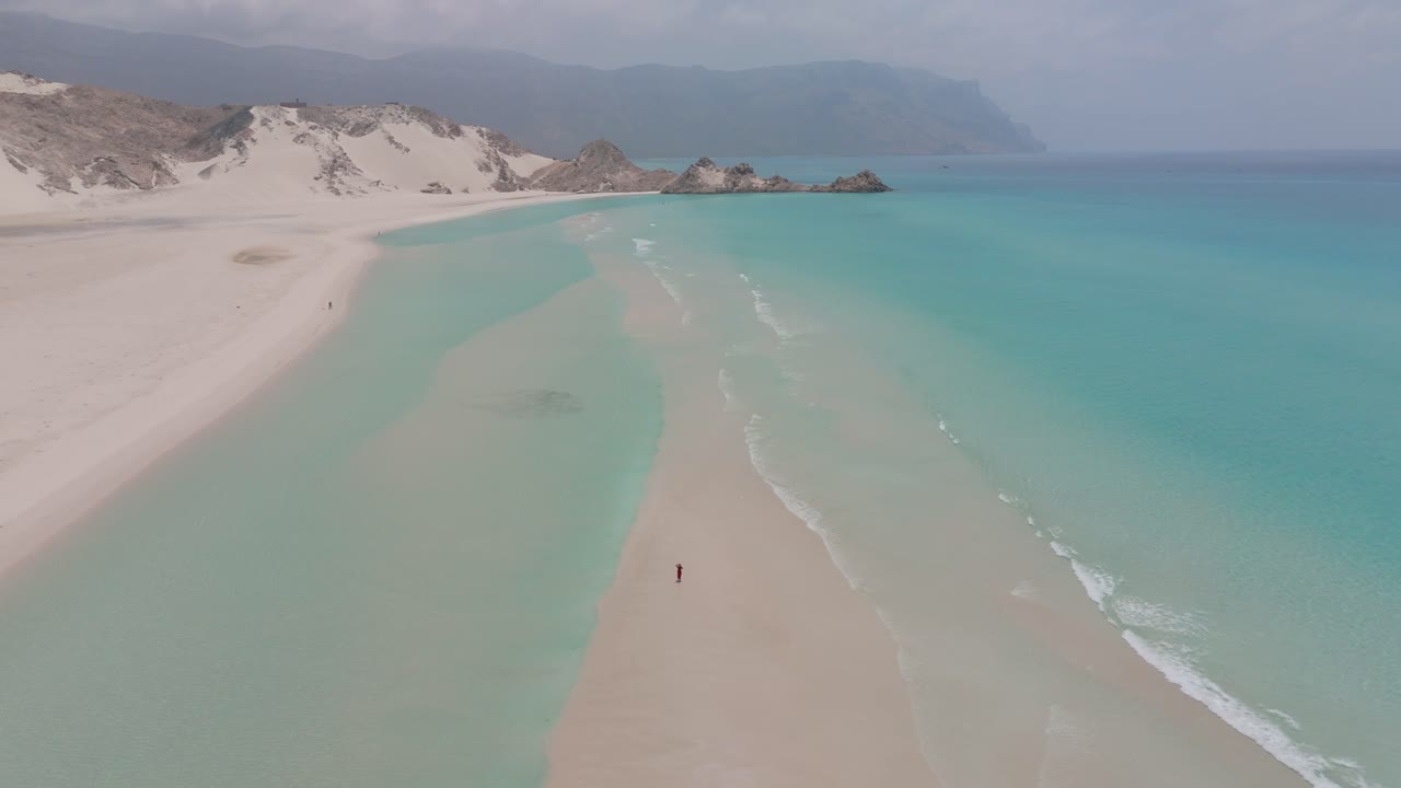 Pessoa correndo em um banco de areia em uma praia em Socotra, Iêmen