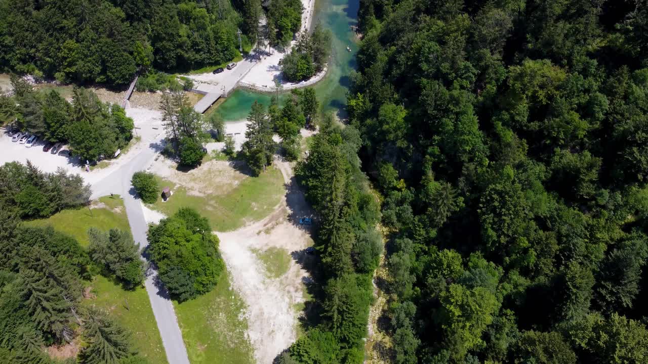 A man-made dam creates a pristine swimming spot in the lush greenery of Idrijska Bela, offering an idyllic nature escape for summer fun
