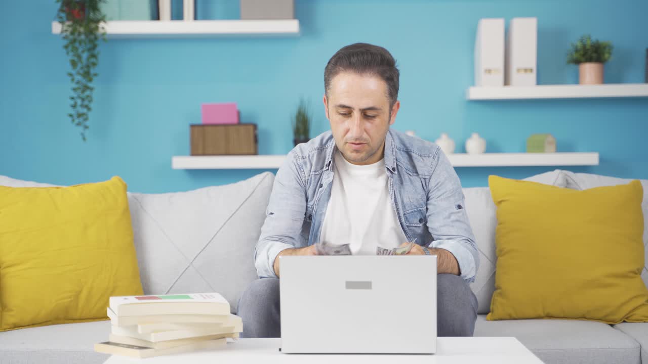 hombre mirando la computadora portátil contando dinero.