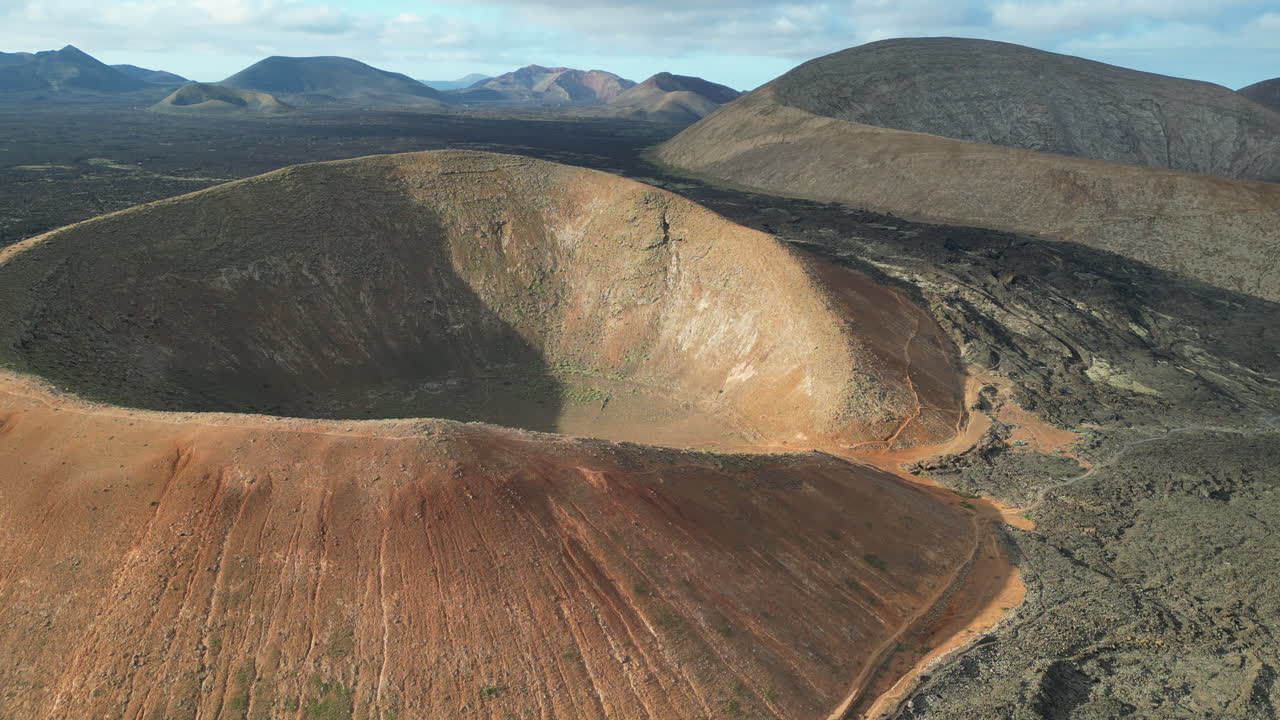 Aerial view of a volcanic landscape with a large crater in Lanzarote, Canary Islands