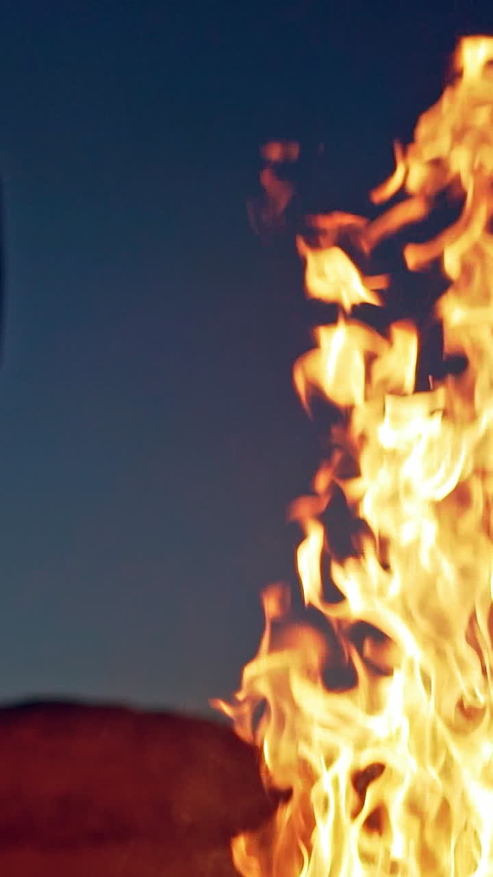 Witch in black near bonfire. Mystical witch walking around bonfire. Vertical video