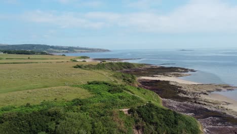 traeth lligwy anglesey eroded coastal shoreline aerial dolly view across welsh weathered hillside coastline