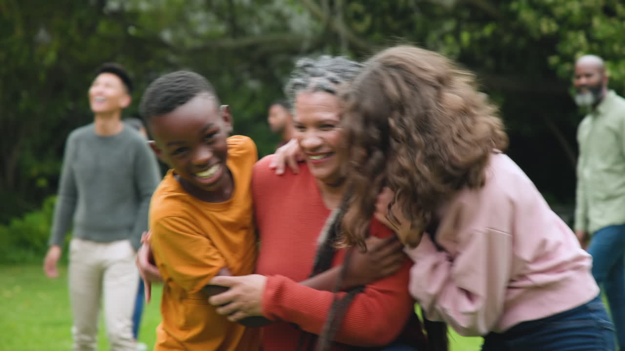 Diverse family laughing and hugging outdoors, enjoying quality time together