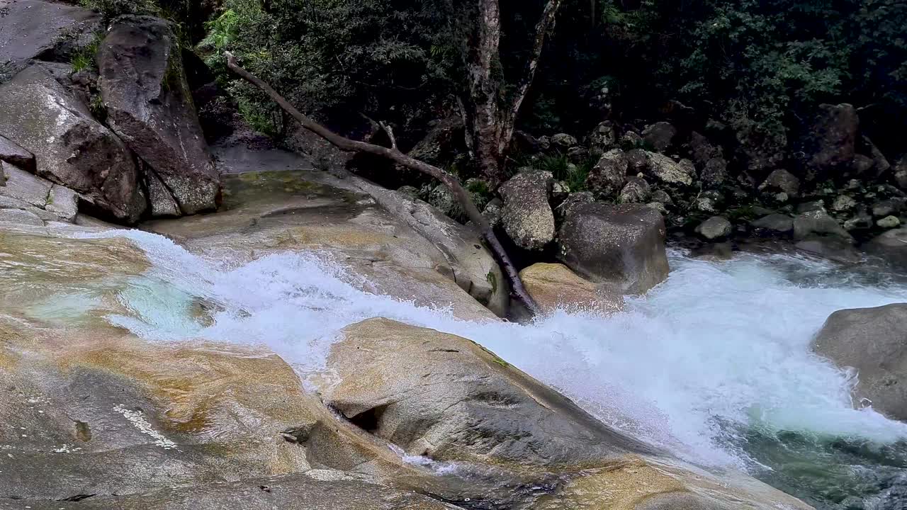 cascada de agua hacia abajo y sobre rocas en josephine falls, cairns, australia