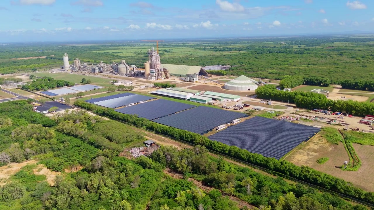 Vista aerea con drone di un grande impianto solare fotovoltaico situato accanto al cementificio Cemento Panam nella Repubblica Dominicana