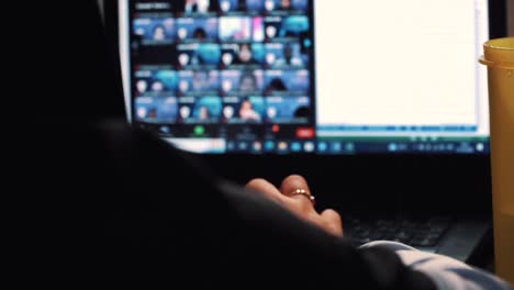 slow motion - close up of a woman wear veil doing group zoom meeting with hand on the laptop keyboard