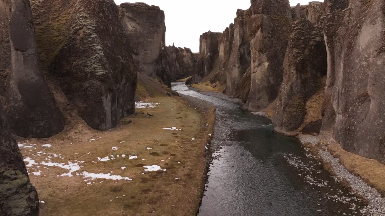 Southern Iceland’s Fjaðrárgljúfur Canyon - drone gliding through towering cliffs, winding river and mossy terrain.