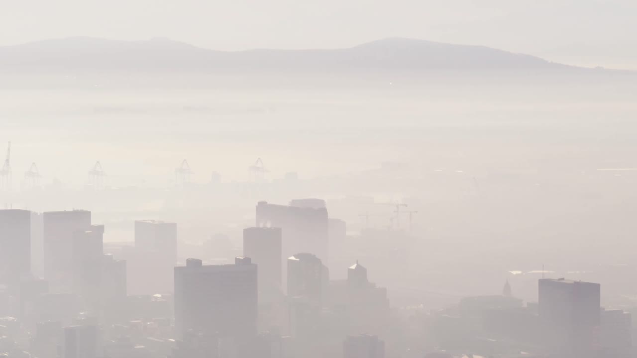 안개로  ⁇ 인 여러 개의 높은 마천루와 건물이 있는 도시 풍경의 일반적인 전망