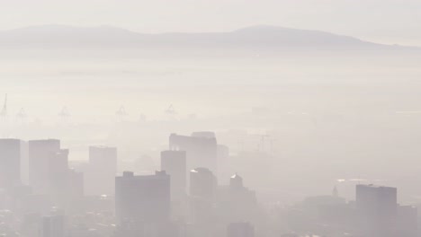 general view of cityscape with multiple tall skyscrapers and buildings covered in fog