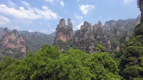 wide pan right showing the iconic forested sandstone towers of zhangjiajie under a clear sky