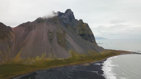 un frailecillo volando cerca del dron en la playa de hofn