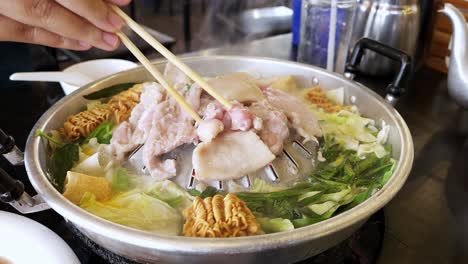 Traditional-grill-pork-BBQ-Thai-style-grilling-with-vegetables-on-the-brass-pan-and-delicious-soup-in-buffet-restaurant-at-dinner