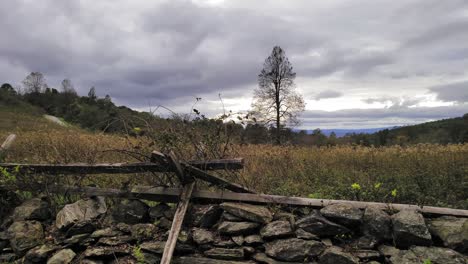 a stacked stone and split rail fence in the countryside