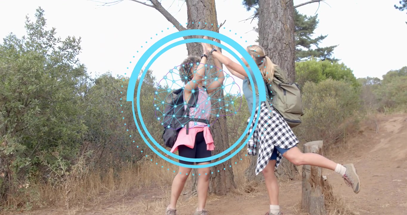 Marketing tecnologico con due donne che si danno il cinque su un sentiero nel bosco, attivando una grafica di rete pulsante.