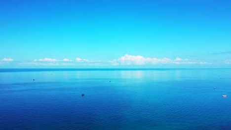 blue ocean with calm water surface reflecting beautiful white clouds and bright sky in barbados, copy space