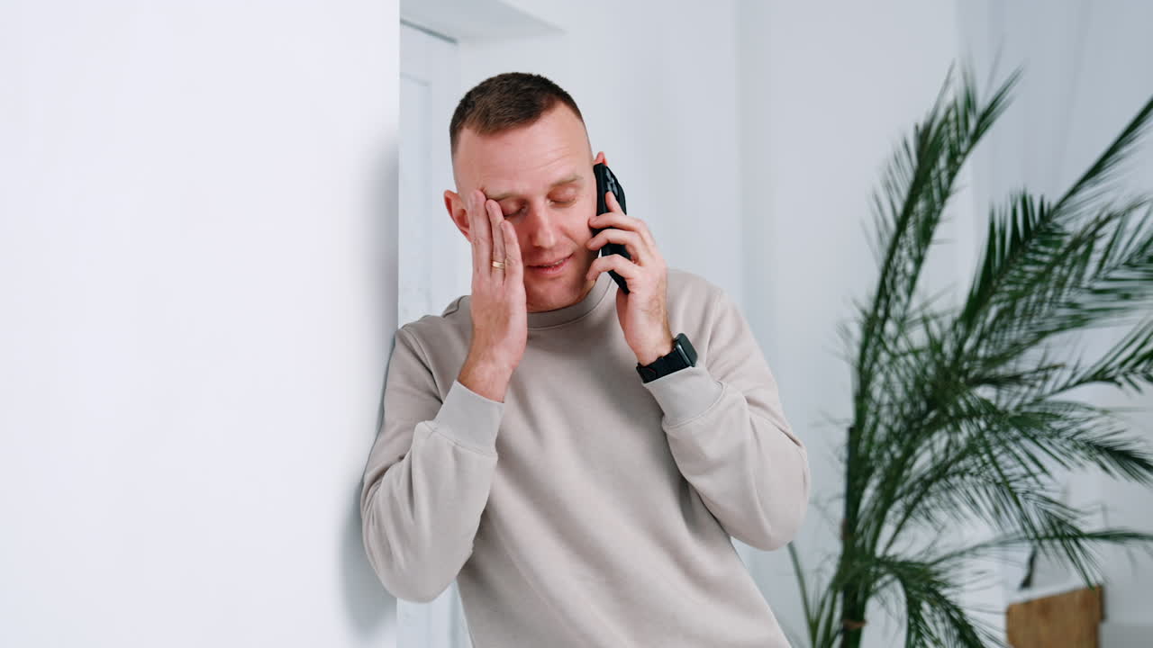 Man hearing the astonishing news on the phone. Caucasian male looks at gadget and continuing to speak.