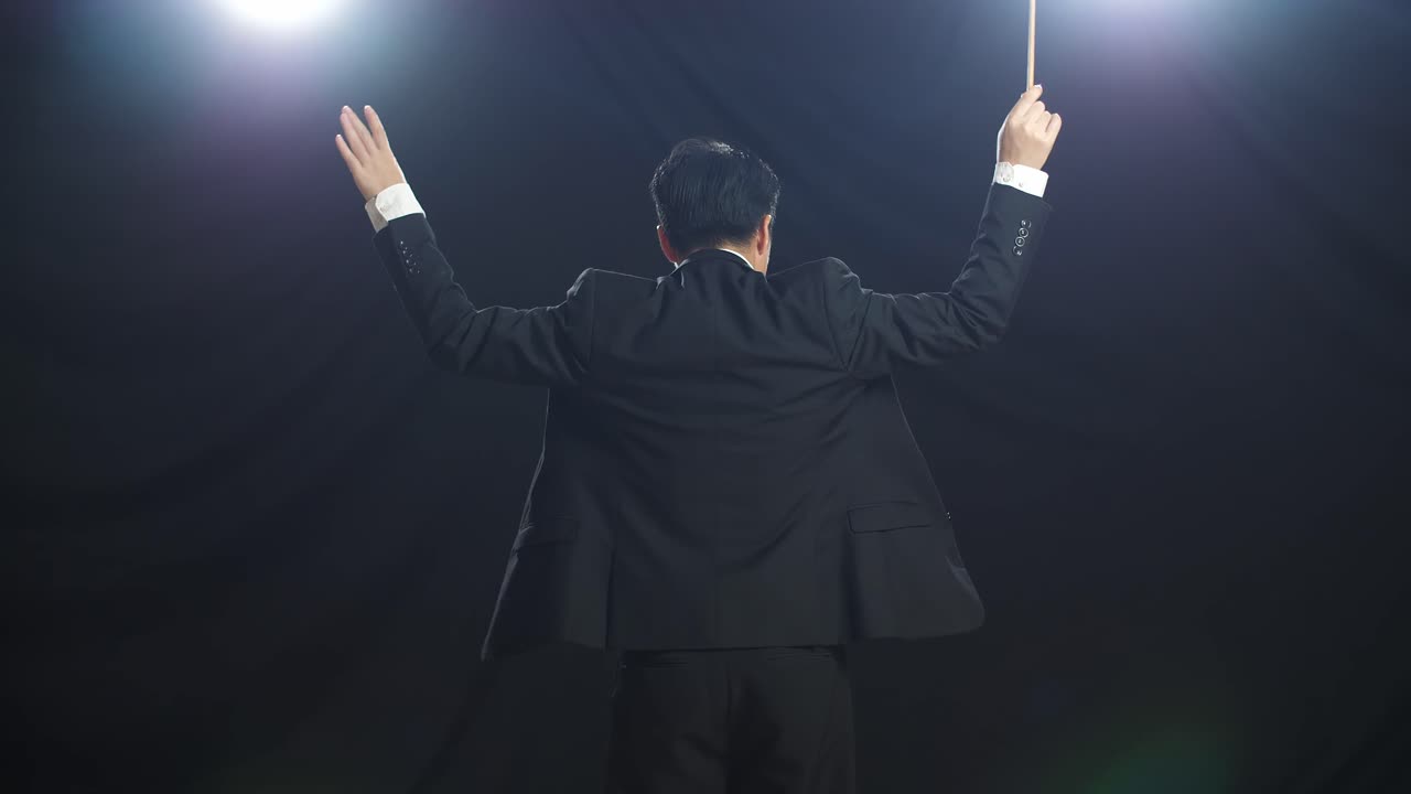 흑인 스튜디오에서 지이를 들고 몸짓을 하는 아시아인 지휘자