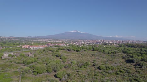 órbita aérea sobre el pueblo bajo el volcán etna en verano