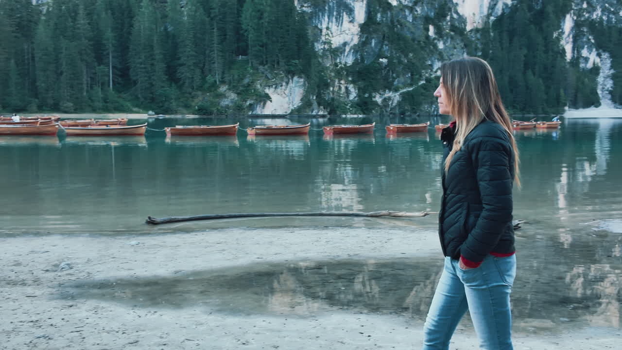 Tourist walking near the alpine lake of Braies in the Italian Dolomites