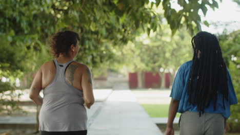 Back-view-of-fat-women-jogging-and-walking-along-path-in-park