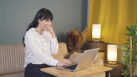 laughing woman using laptop at night.