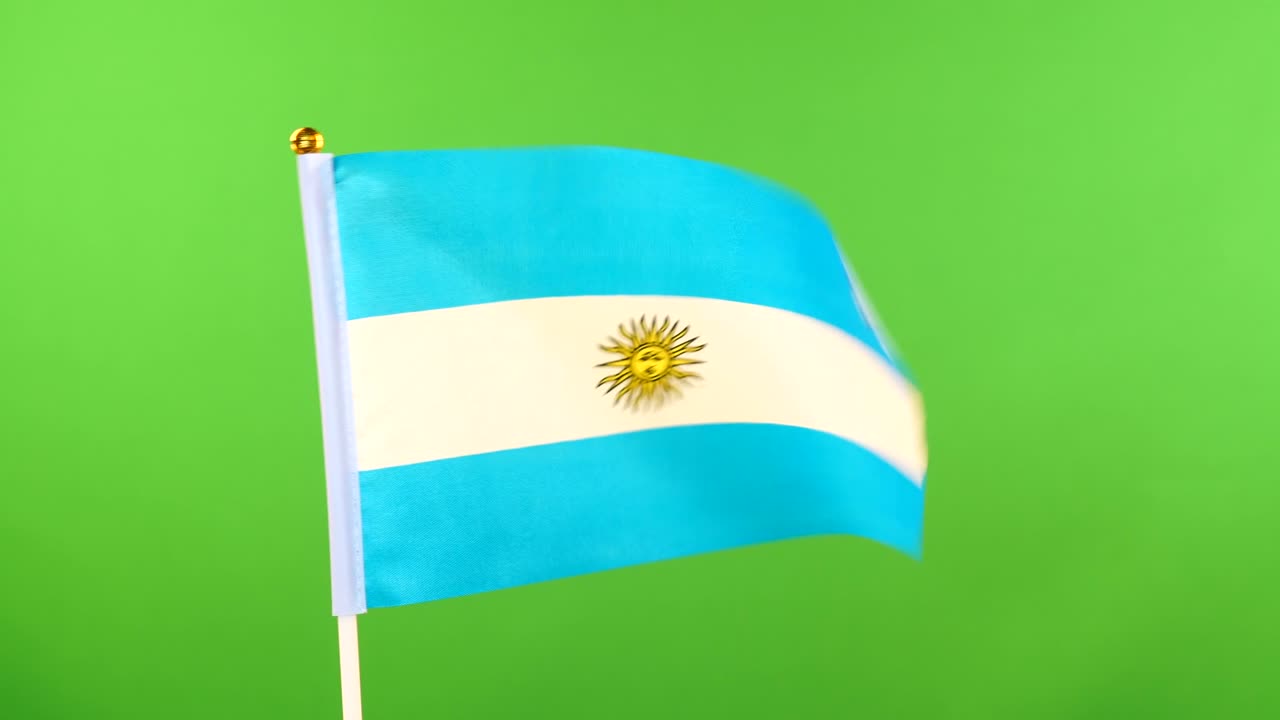 bandera de argentina en el mástil sobre un fondo verde. bandera argentina ondeando en el viento.