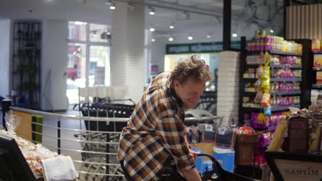 healthy and natural food. smiling and cheerful caucasian man weighing a bunch of bananas, putting on sticker and move on. slow motion