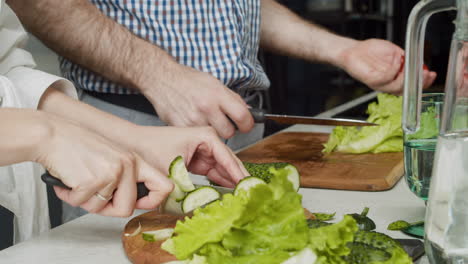 close up of couple hands preparing food together in a modern kitchen