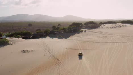 aerial: buggy driving through the dunes of cumbuco