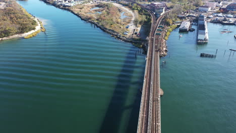 A-high-angle-shot-over-elevated-train-tracks-crossing-a-bay-in-Queens,-NY