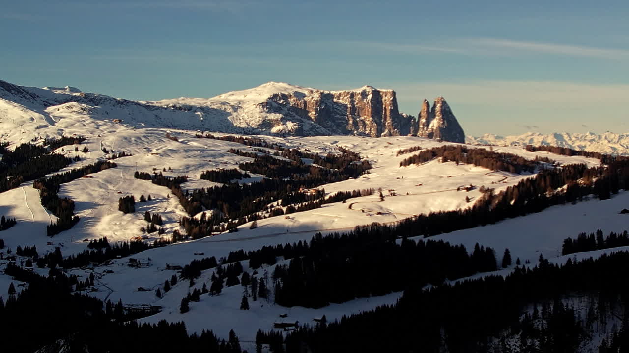 imágenes aéreas capturando el amanecer dorado sobre las laderas nevadas de schlern y seiser alm en los dolomitas