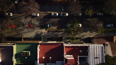 cinematic top-down aerial turning overhead of the house and the road, a beautiful parallel of the house to the road, the roofs are separated