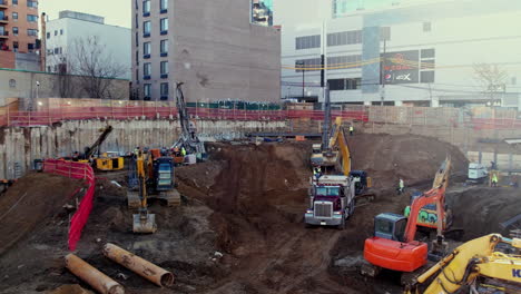 digger excavators dig dirt into truck in inner city jobsite during the morning