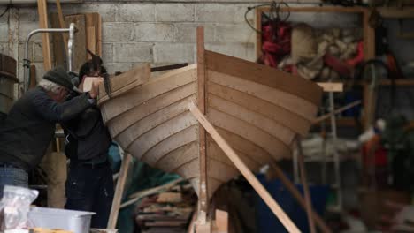 handmade wooden boat, skilled craftsmen fitting sheer strake