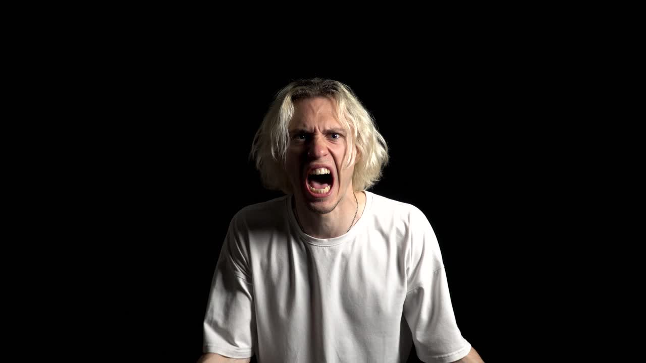 좌절한 젊은 남자가 폐 위에서 분노로 비명을 지르고 있습니다.