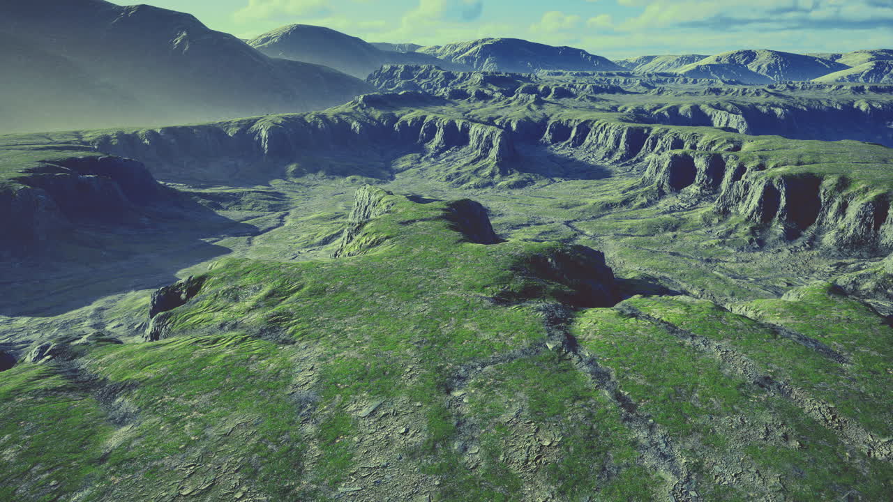 Vast green landscape under a bright sky with distant mountains and valleys