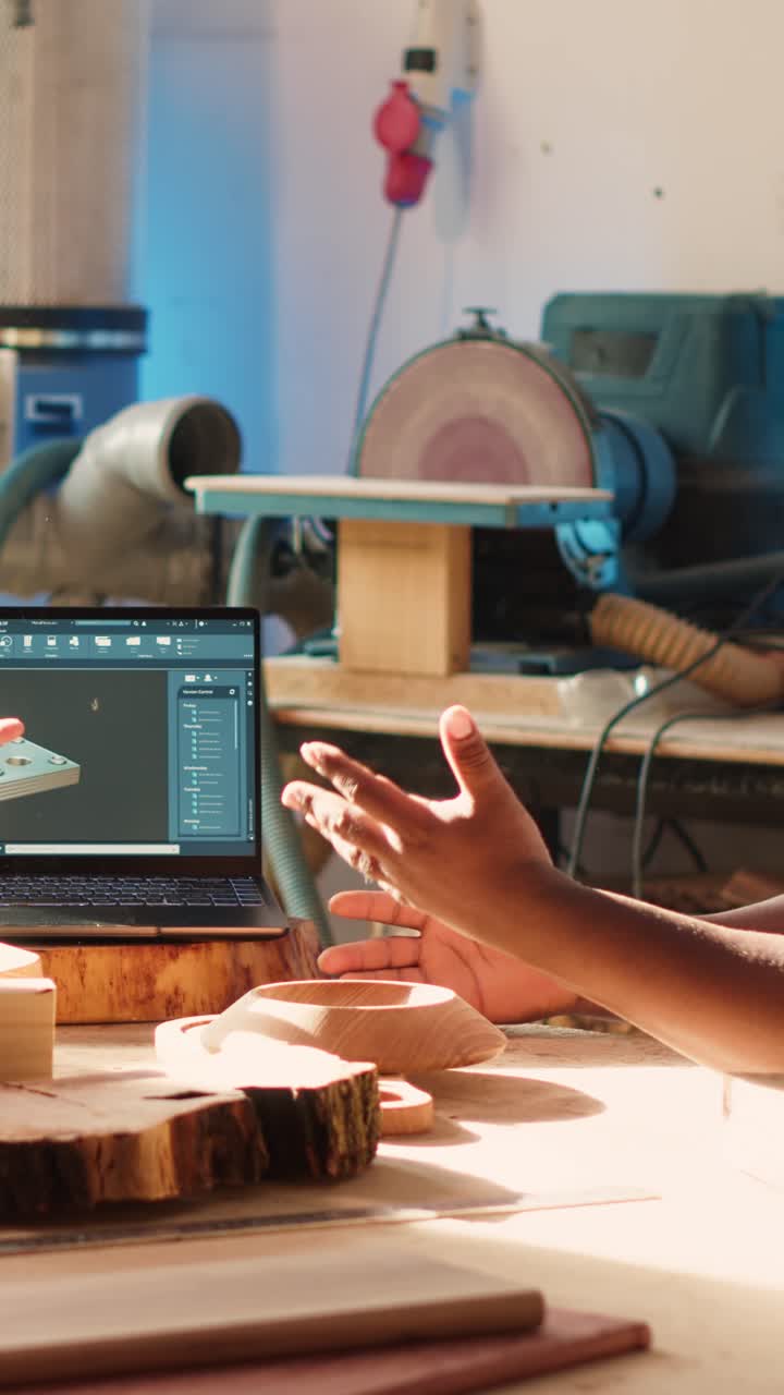 Artesanos que usan un portátil para diseño 3D en un taller de carpintería