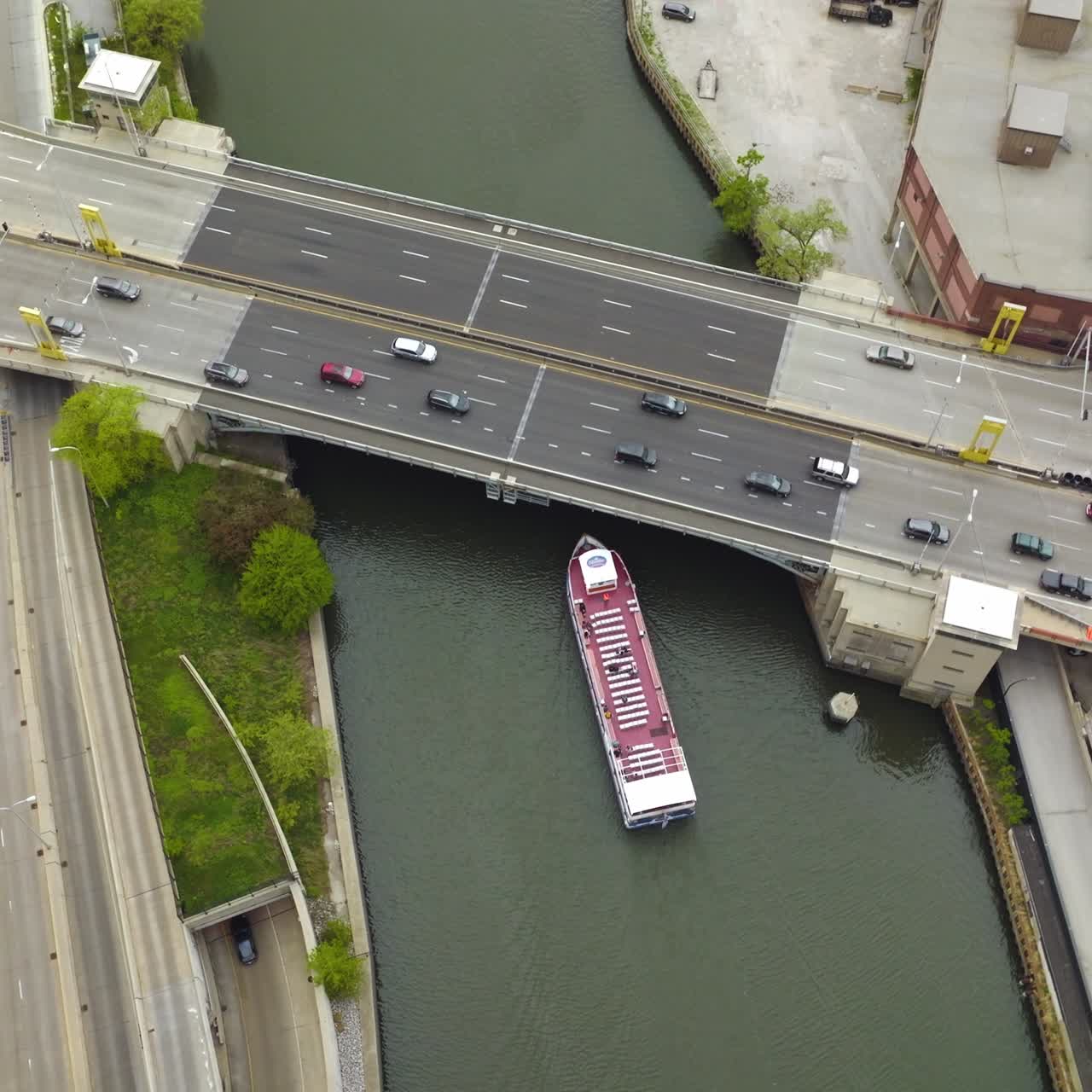 Big boat going under the bridge with cars riding on it. Lively traffic in Chicago, Illinois from bird's eye view