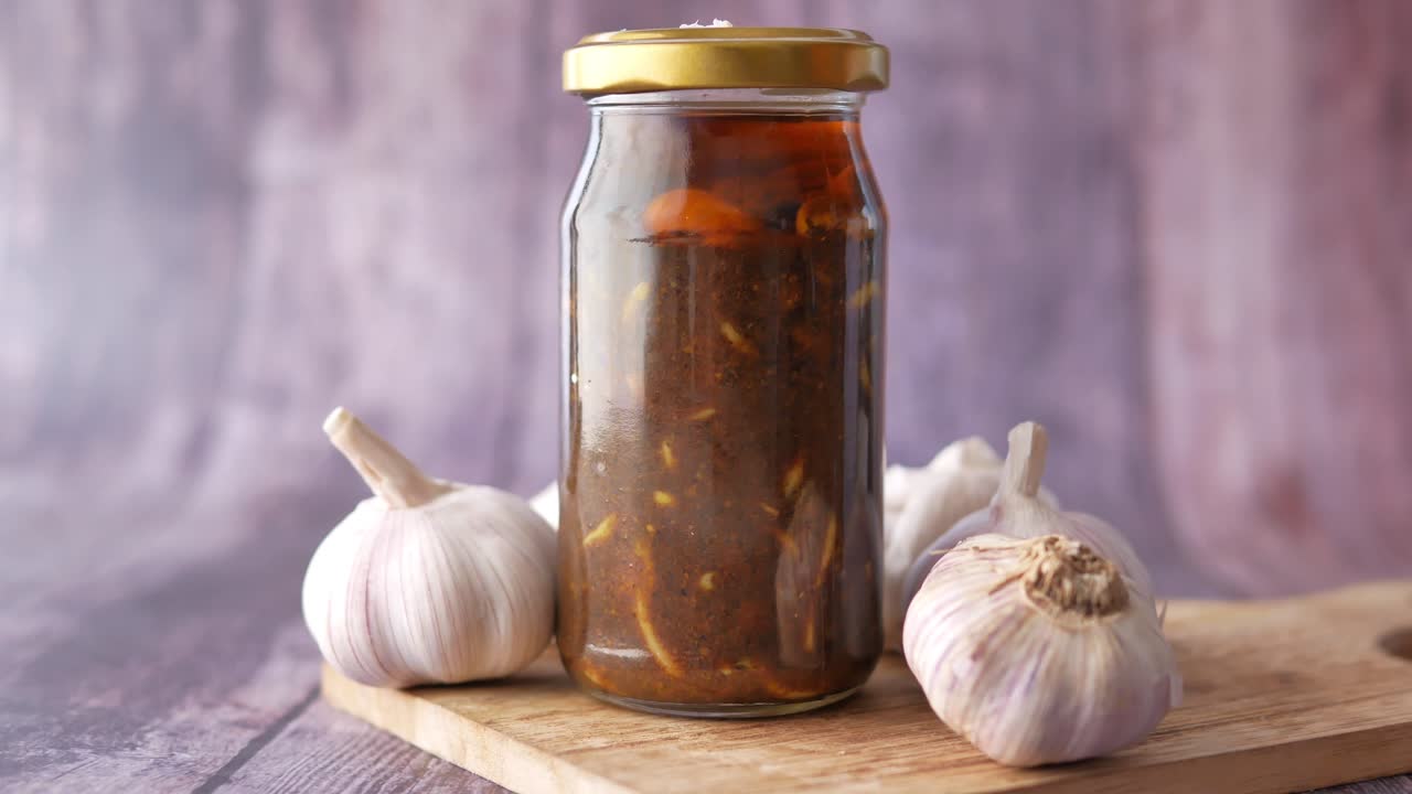 Homemade garlic pickle in a glass jar on table ,