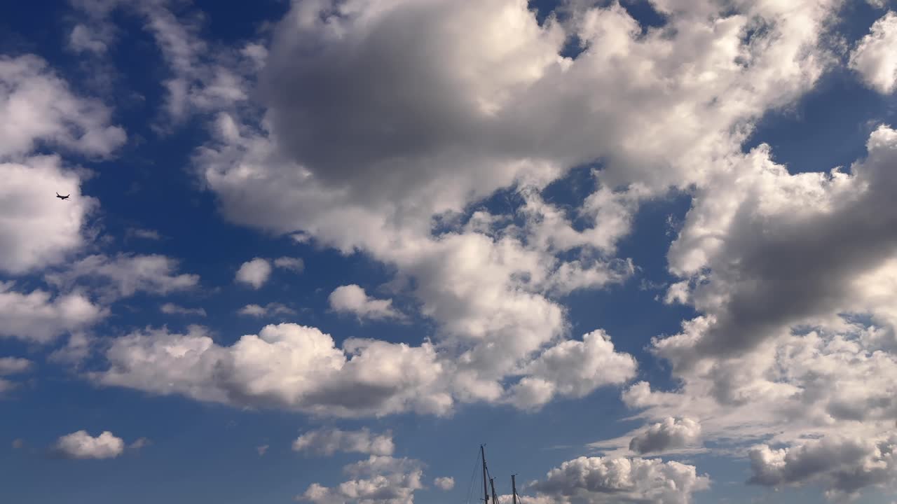 Airplane flying across a cloudy sky above the seaport marina in Heraklion Crete Greece