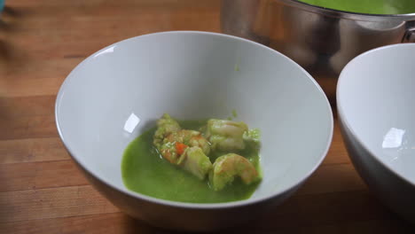 ladling cilantro seafood soup in a bowl - close up, real-time