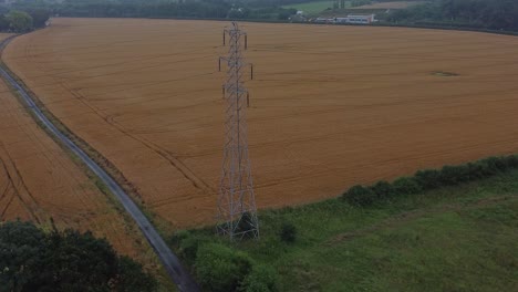 Strom-Stahlmast-Hochspannungsdrähte-In-Der-Landschaft-Landwirtschaftlichen-Bauernhof-Feld-Luftaufnahme-Am-Frühen-Morgen-Umlaufbahn-Rechts