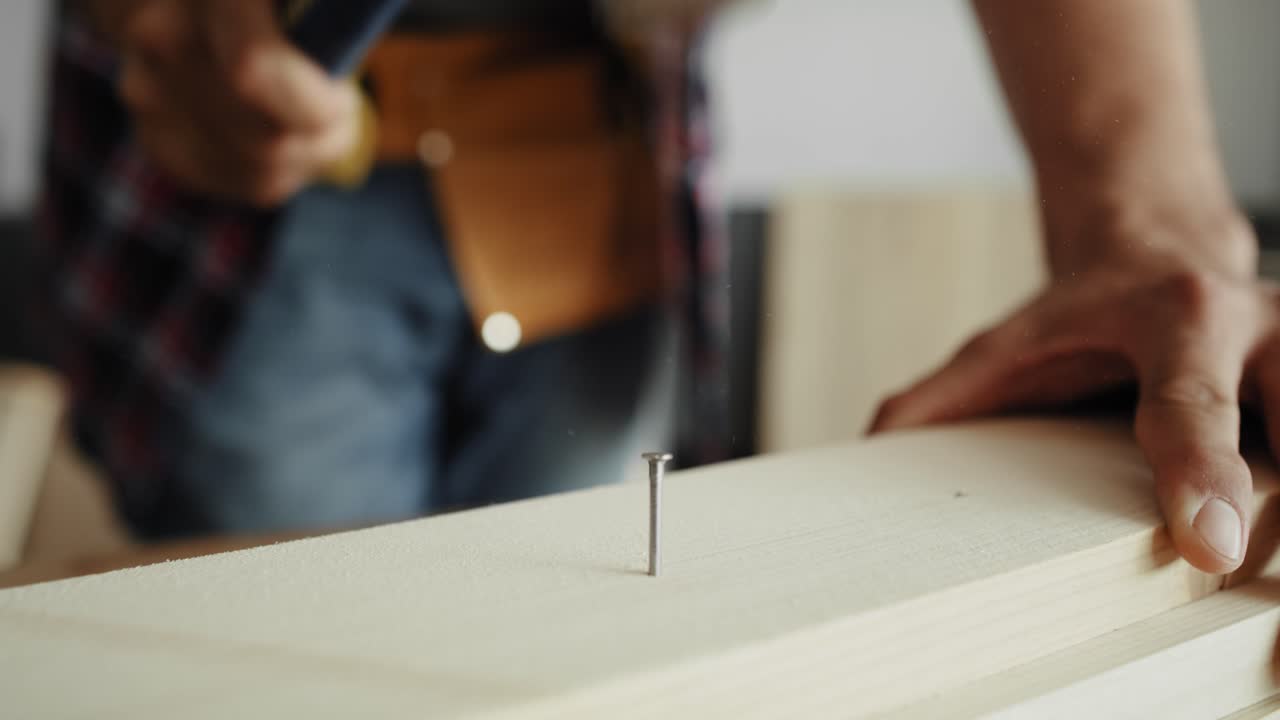 detalle del video de un carpintero usando un martillo para clavar clavos