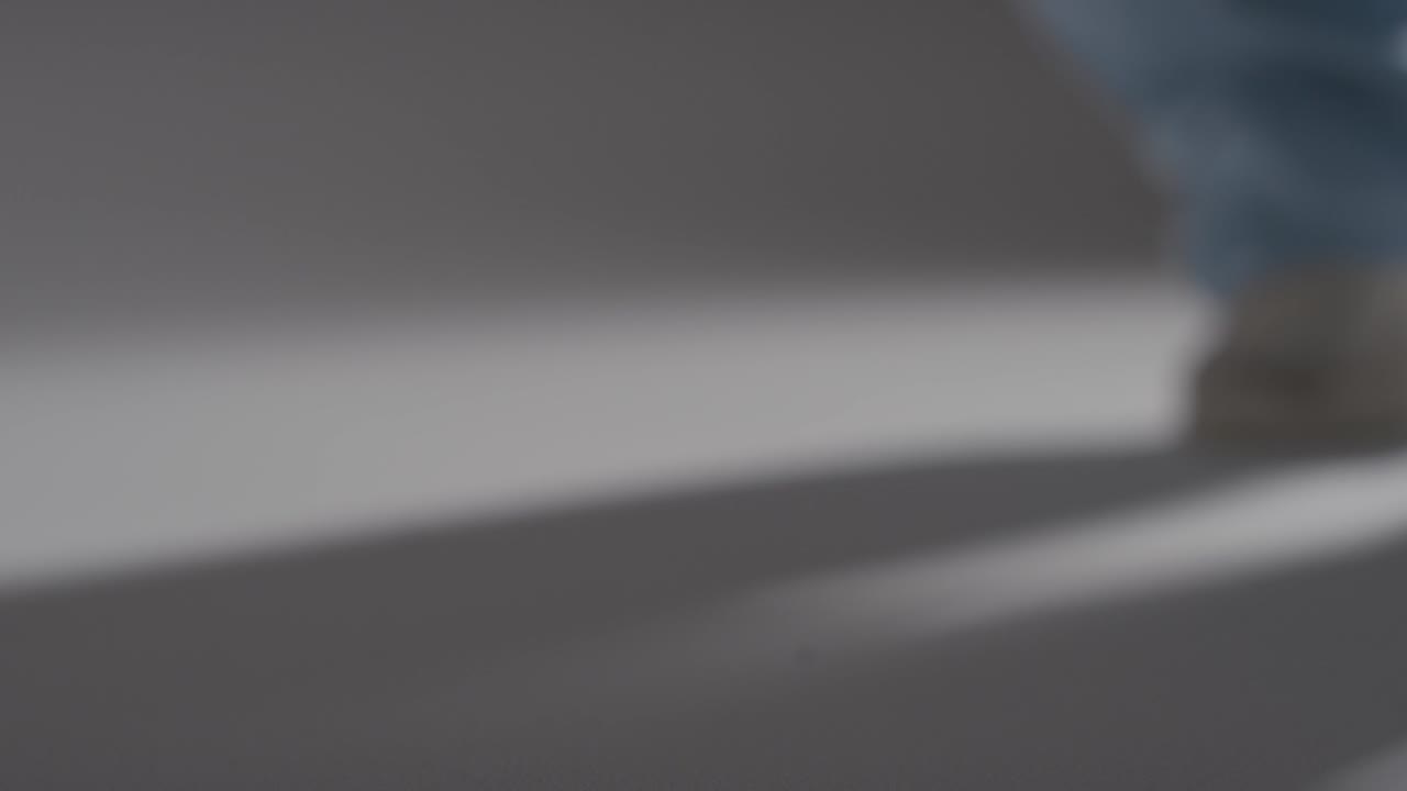 Defocused Close Up Of Legs And Feet Of Woman Dancing Against White Studio Background